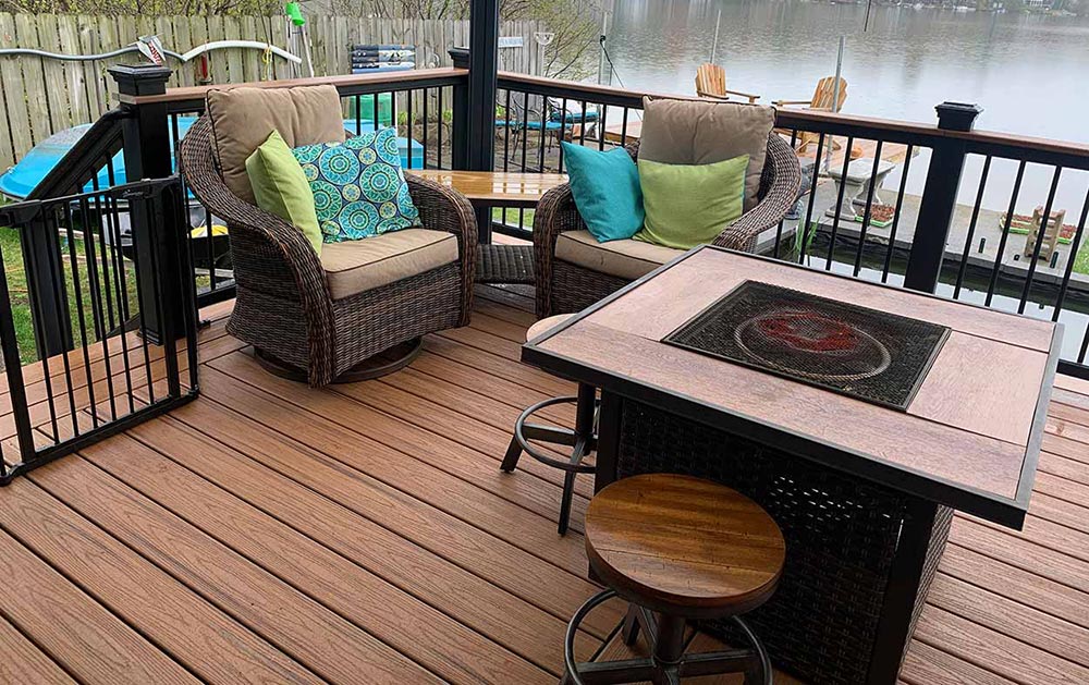 Custom Deck | Medium tone dark wood deck with dark railings and furniture | Backyard Creations | Custom Decks, Porches, and Pergolas