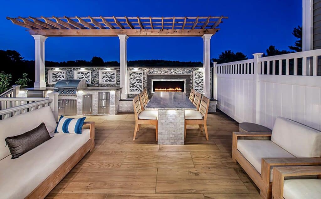 Wood deck with chairs, couch, grill, fence, and structure